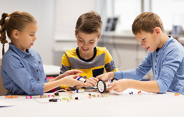 Image showing happy children building robots at robotics school