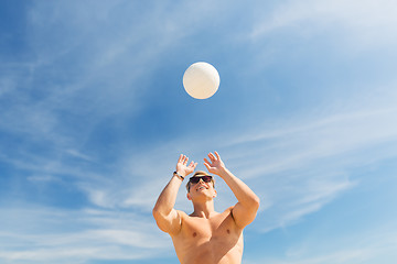 Image showing young man with ball playing volleyball on beach