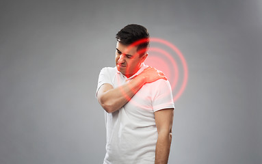 Image showing unhappy man suffering from pain in shoulder
