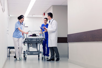 Image showing medics with woman on hospital gurney at emergency