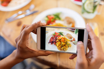 Image showing hands with smartphone picturing food at restaurant