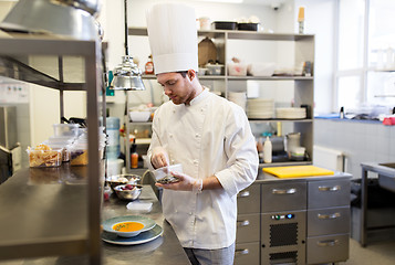 Image showing happy male chef cooking food at restaurant kitchen