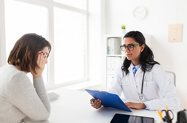 Image showing doctor with clipboard and woman patient at clinic