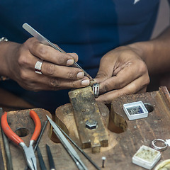 Image showing Jeweler making handmade jewelry on vintage workbench.