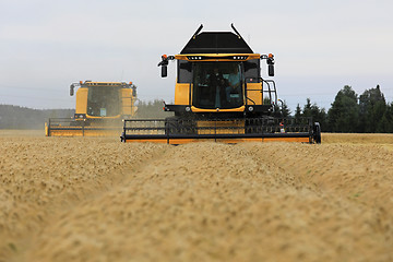 Image showing Two Yellow New Holland Combines on Field