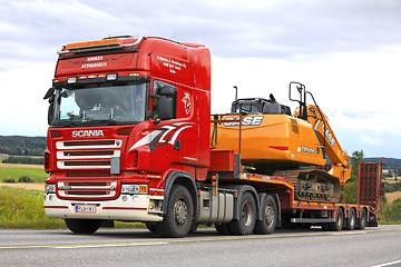 Image showing Red Scania Semi Trailer Hauls New Case Excavator