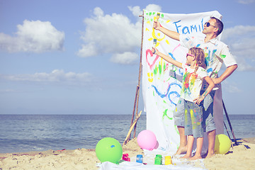 Image showing Father and daughter playing on the beach at the day time.