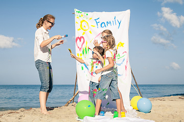 Image showing Mother and children playing on the beach at the day time.