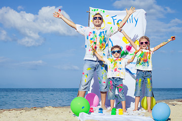 Image showing Father and children playing on the beach at the day time.