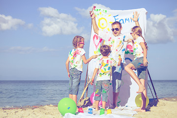 Image showing Father and children playing on the beach at the day time.