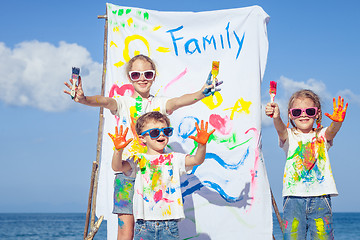 Image showing Two sisters and brother playing on the beach at the day time.