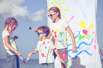 Image showing Two sisters and brother playing on the beach at the day time.