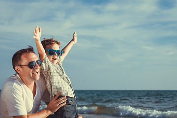 Image showing Father and son playing on the beach at the day time.