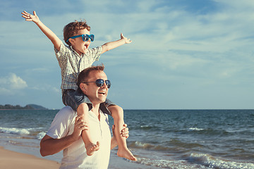 Image showing Father and son playing on the beach at the day time.