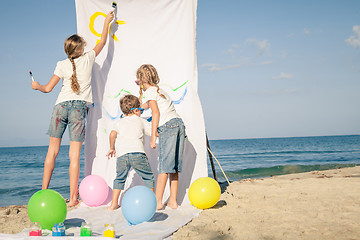 Image showing Two sisters and brother playing on the beach at the day time.