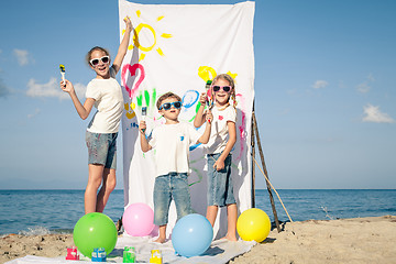 Image showing Two sisters and brother playing on the beach at the day time.