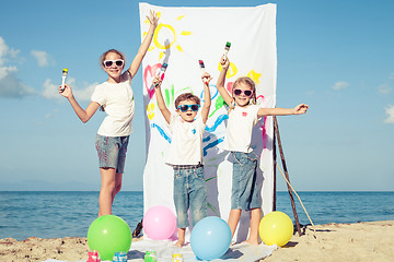 Image showing Two sisters and brother playing on the beach at the day time.