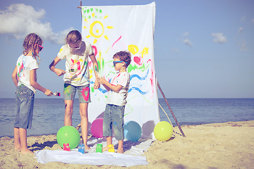 Image showing Two sisters and brother playing on the beach at the day time.