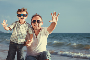 Image showing Father and son playing on the beach at the day time.