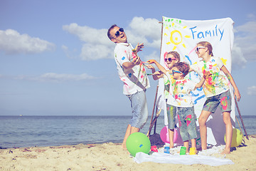 Image showing Father and children playing on the beach at the day time.