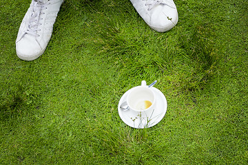 Image showing an empty cup of coffee in the grass