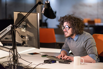 Image showing man working on computer in dark startup office