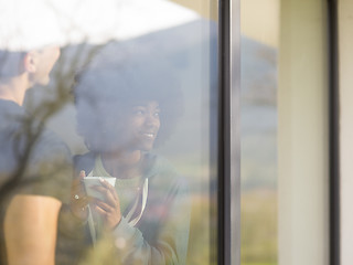 Image showing happy multiethnic couple relaxing at modern home indoors