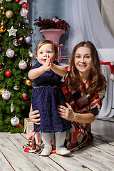 Image showing Little girl With her happy mother at studio with christmas decorations