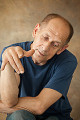 Image showing Worried mature man sitting at studio