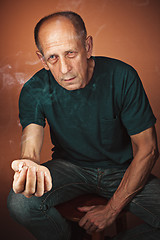 Image showing Worried mature man sitting at studio