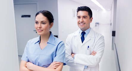 Image showing smiling doctor in white coat and nurse at hospital