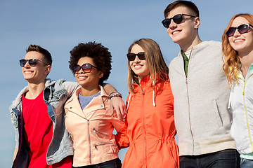 Image showing happy teenage friends in shades talking on street