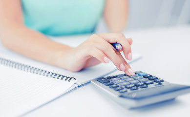 Image showing businesswoman working with calculator in office