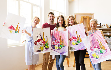 Image showing group of artists with pictures at art school