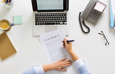 Image showing businesswoman signing contract document at office