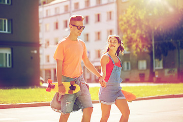 Image showing teenage couple with skateboards on city street