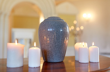 Image showing cremation urn and candles burning in church