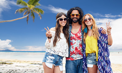 Image showing happy hippie friends showing peace on summer beach