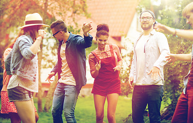 Image showing happy friends dancing at summer party in garden