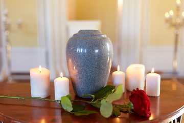 Image showing red rose and cremation urn with burning candles