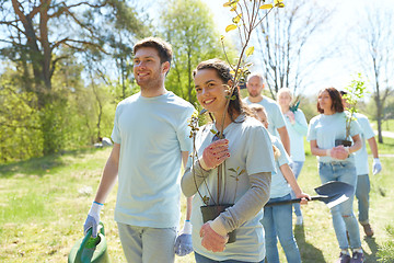 Image showing group of volunteers with trees and rake in park