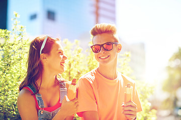 Image showing happy teenage couple eating hot dogs in city