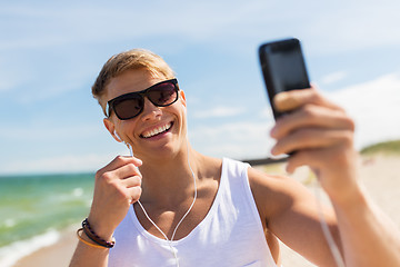 Image showing man with smartphone taking selfie on summer beach