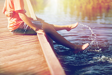 Image showing happy teenage couple sitting on river berth