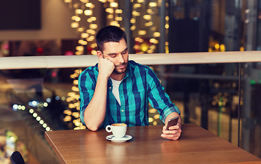 Image showing man with smartphone and coffee at restaurant