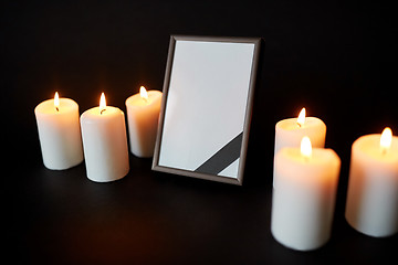 Image showing black ribbon on photo frame and candles at funeral