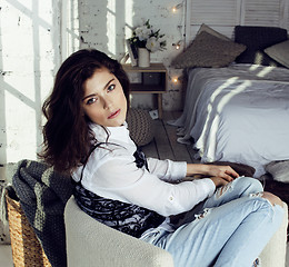 Image showing young pretty brunette woman in her bedroom sitting at window, happy smiling lifestyle people concept 