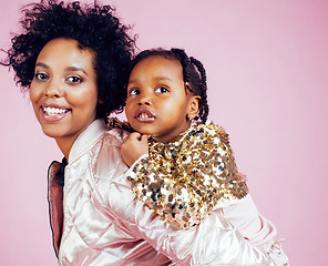 Image showing young pretty african-american mother with little cute daughter hugging, happy smiling on pink background, lifestyle modern people concept 