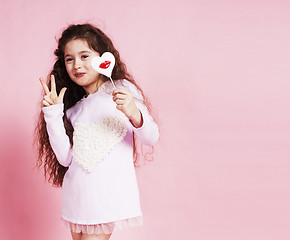 Image showing little cute girl with candy on pink background posing emotional, lifestyle people concept 