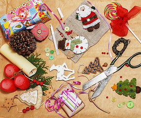 Image showing handmade christmas gifts in mess with toys, candles, fir, ribbon, tree cone wooden vintage, post card view 